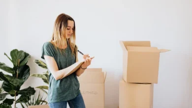 Glad woman writing down notes during while packing.